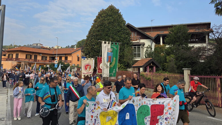 Il corteo della Marcia per la Pace attraversa Villarbasse con lo striscione dei ragazzi e il gonfalone comunale